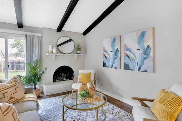 living room with lofted ceiling with beams, hardwood / wood-style flooring, a fireplace, and a textured ceiling