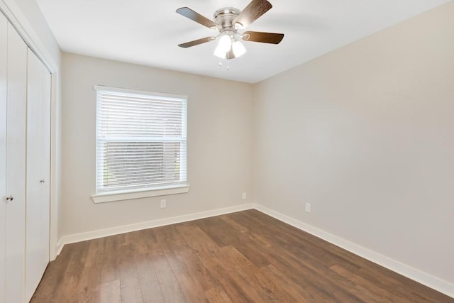 unfurnished bedroom featuring dark hardwood / wood-style floors, ceiling fan, and a closet