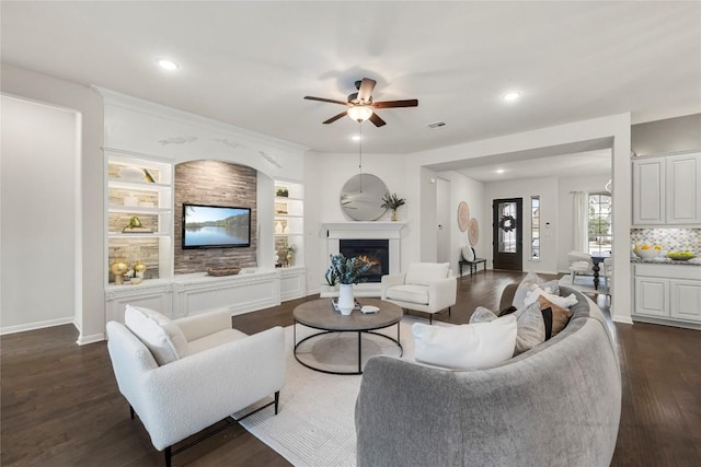 living room featuring dark wood-type flooring and ceiling fan