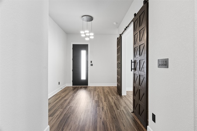 foyer with an inviting chandelier, dark hardwood / wood-style floors, and a barn door