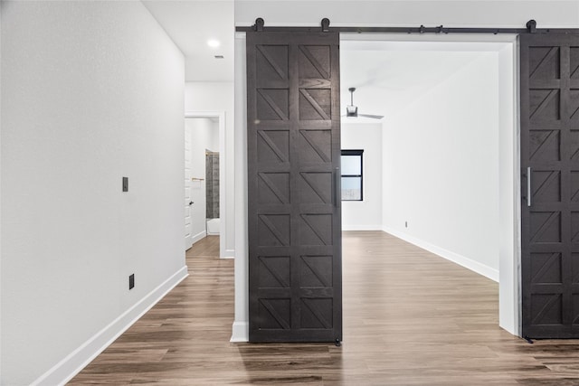 corridor featuring hardwood / wood-style flooring and a barn door