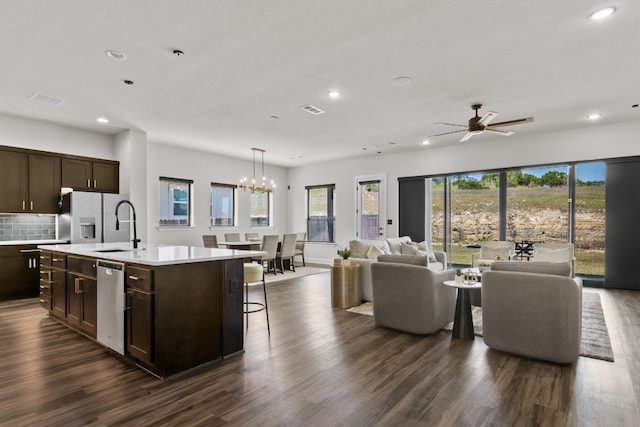 313 Starfire Dr, Dripping Springs, TX 78620 - kitchen featuring recessed lighting, appliances with stainless steel finishes, open floor plan, dark brown cabinetry, and light countertops