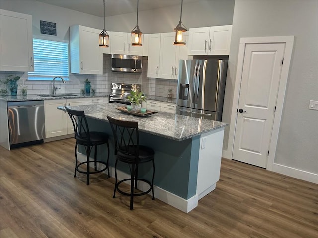 kitchen featuring white cabinetry, appliances with stainless steel finishes, sink, and a kitchen island