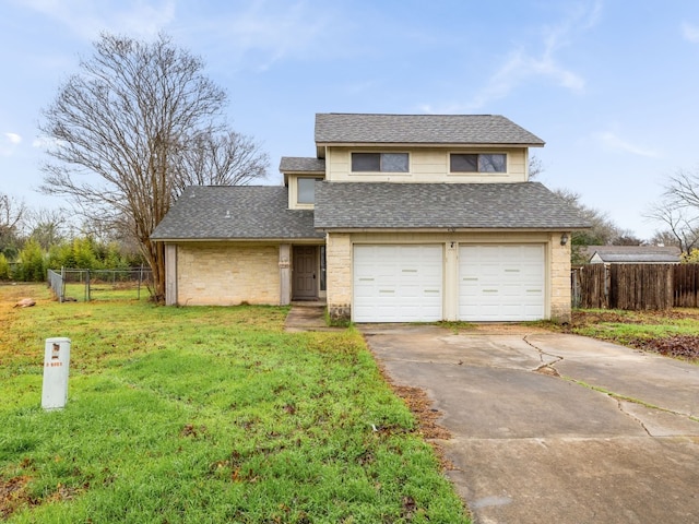 traditional-style house featuring fence, an attached garage, driveway, and a front lawn