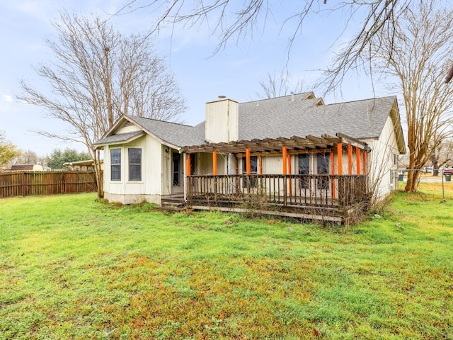 back of property with a wooden deck and a lawn