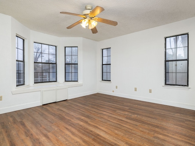 empty room with dark hardwood / wood-style flooring, ceiling fan, and a textured ceiling