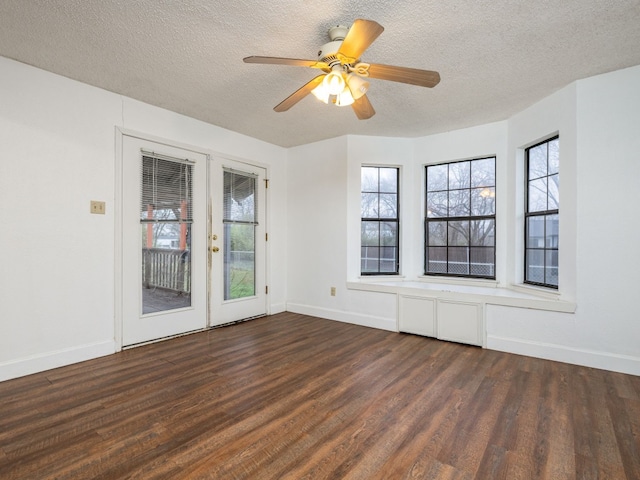 unfurnished room featuring french doors, a healthy amount of sunlight, dark hardwood / wood-style floors, and a textured ceiling