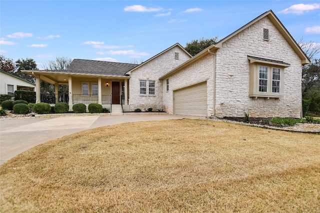 view of front of house featuring a garage, a porch, and a front lawn