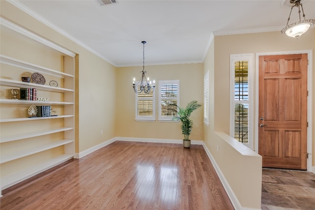 interior space featuring crown molding, hardwood / wood-style floors, built in shelves, and plenty of natural light