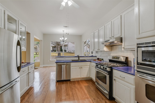 kitchen with appliances with stainless steel finishes, sink, and white cabinets