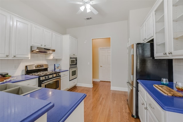 kitchen with sink, stainless steel appliances, tasteful backsplash, white cabinets, and light wood-type flooring