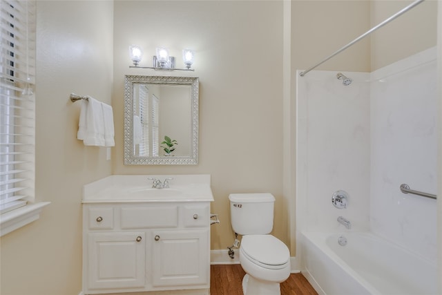 full bathroom with hardwood / wood-style flooring, washtub / shower combination, vanity, and toilet