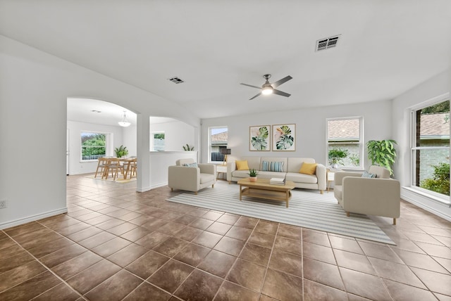 unfurnished living room featuring dark tile patterned floors, plenty of natural light, and ceiling fan