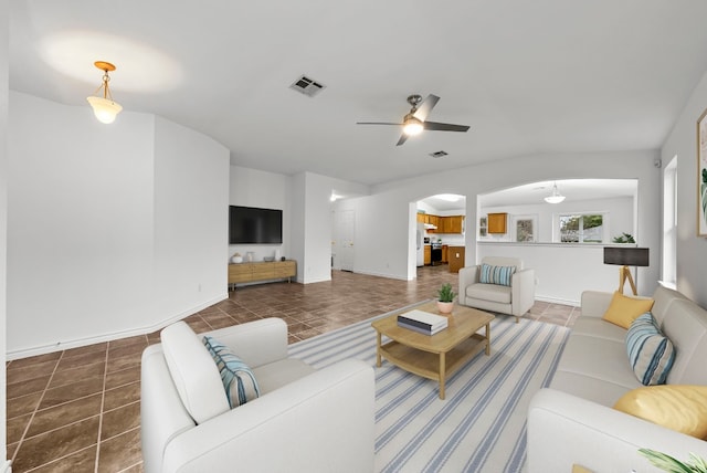 living room with dark tile patterned flooring and ceiling fan