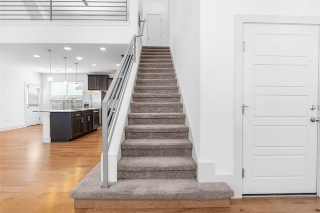 2211 Capulet St, Austin, TX 78741 - stairs with wood finished floors, recessed lighting, and baseboards