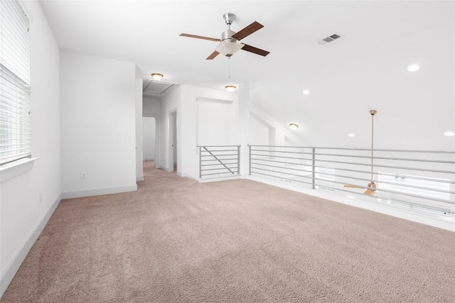 2211 Capulet St, Austin, TX 78741 - empty room featuring a ceiling fan, light carpet, attic access, baseboards, and vaulted ceiling