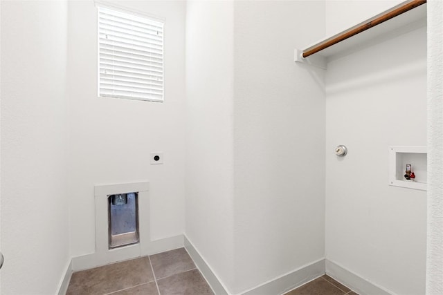 2211 Capulet St, Austin, TX 78741 - laundry area featuring hookup for an electric dryer, light tile patterned floors, hookup for a washing machine, and baseboards