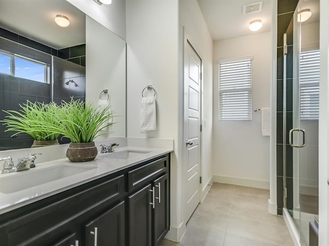 2211 Capulet St, Austin, TX 78741 - bathroom featuring double vanity, a shower stall, tile patterned floors, and baseboards