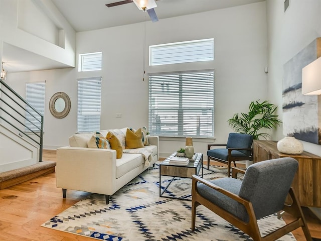 2211 Capulet St, Austin, TX 78741 - living area featuring wood finished floors, stairs, a high ceiling, and a ceiling fan