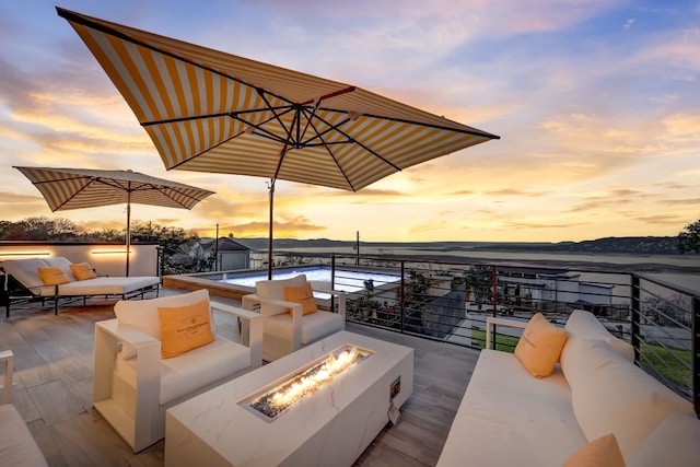 patio terrace at dusk featuring an outdoor living space with a fire pit