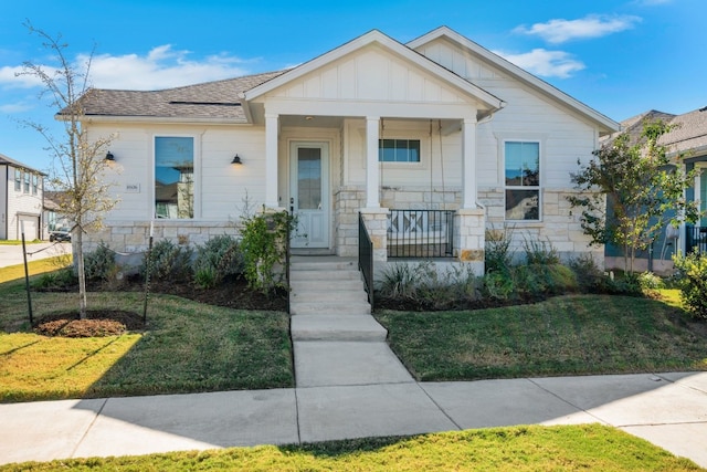 bungalow featuring a front lawn and a porch