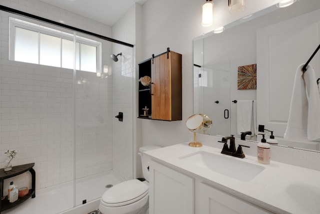 bathroom featuring vanity, a shower with door, and toilet