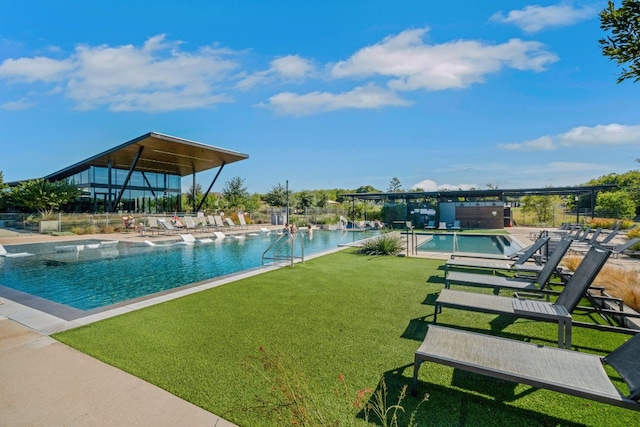 view of pool featuring a patio and a yard