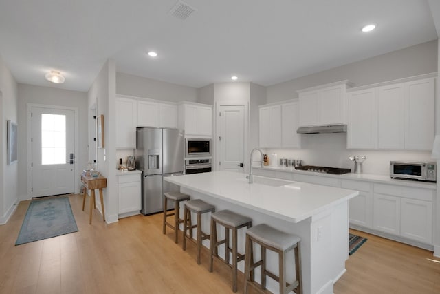 kitchen featuring white cabinetry, sink, a center island with sink, and appliances with stainless steel finishes