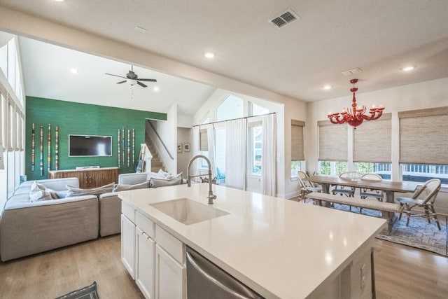 kitchen featuring sink, white cabinetry, stainless steel dishwasher, a kitchen island with sink, and light hardwood / wood-style floors