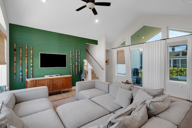 living room featuring vaulted ceiling, ceiling fan, and light hardwood / wood-style flooring