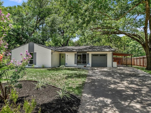 ranch-style home featuring a carport, a garage, and a front yard