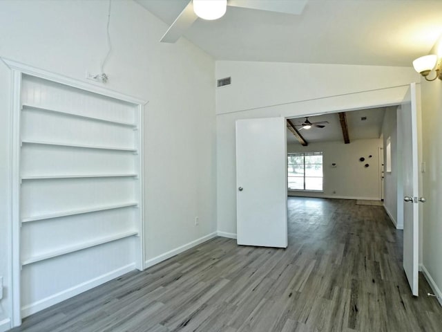 empty room featuring wood-type flooring, vaulted ceiling with beams, and ceiling fan