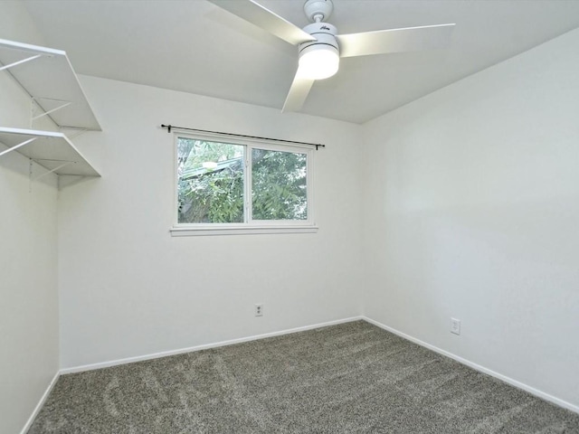 spare room featuring ceiling fan and dark colored carpet