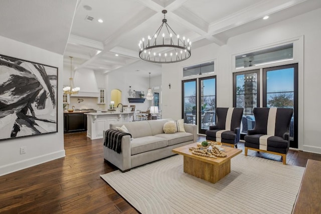 living area with dark wood-type flooring, coffered ceiling, and a notable chandelier