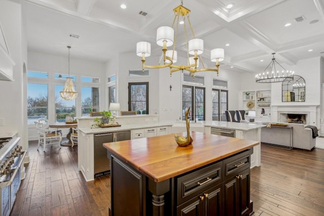 kitchen featuring pendant lighting, dark brown cabinets, a center island, and a chandelier