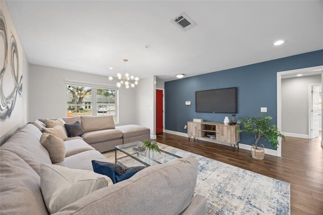 living room with an inviting chandelier and dark wood-type flooring