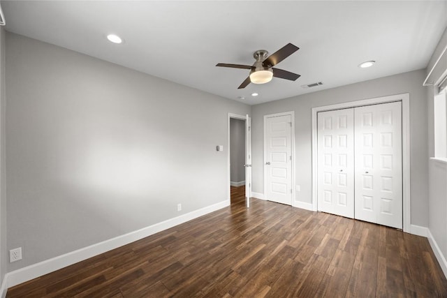 unfurnished bedroom with ceiling fan, dark hardwood / wood-style flooring, and a closet