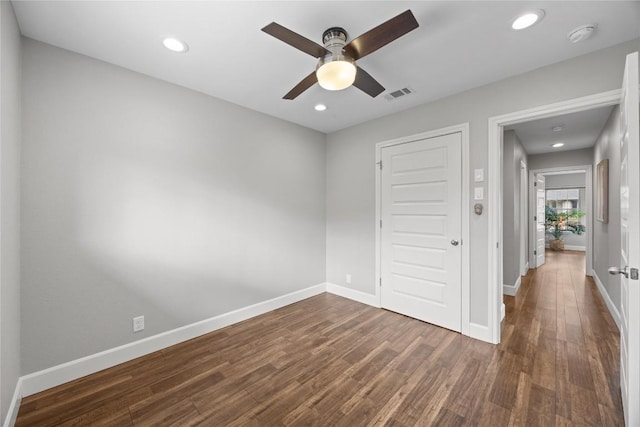 empty room with dark hardwood / wood-style floors and ceiling fan