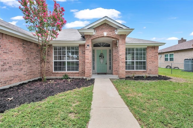 property entrance featuring central AC and a lawn