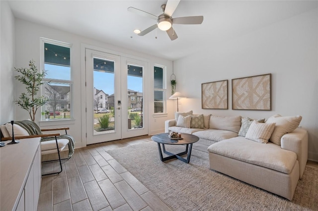 living room with light wood-type flooring, french doors, and ceiling fan