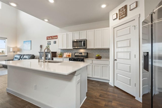 116 Big Cypress Bayou Rd, Hutto, TX 78634 - kitchen with stainless steel appliances, a sink, dark wood finished floors, decorative backsplash, and recessed lighting