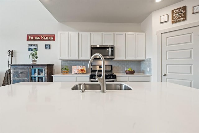 kitchen with appliances with stainless steel finishes, white cabinets, and decorative backsplash