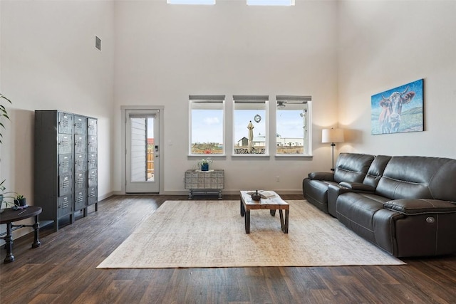 living room with a high ceiling and dark hardwood / wood-style flooring