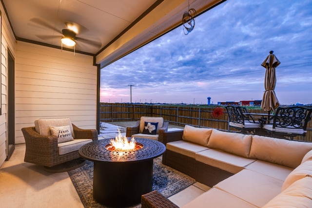 patio terrace at dusk with an outdoor living space with a fire pit and ceiling fan