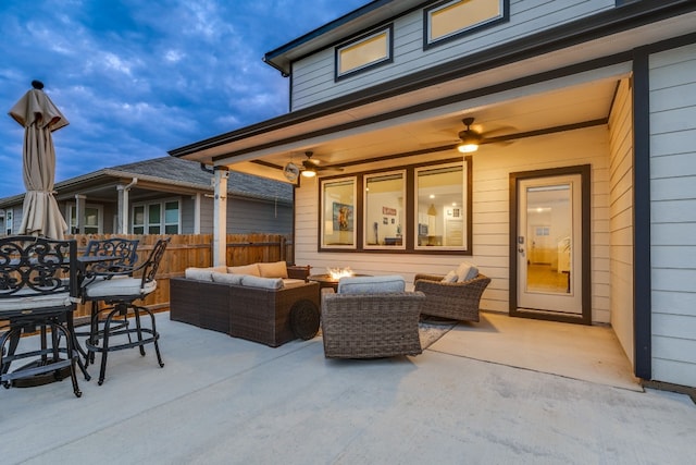 view of patio featuring ceiling fan and an outdoor living space with a fire pit