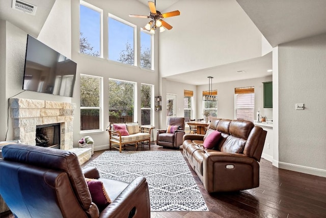 living room featuring dark hardwood / wood-style flooring, a fireplace, and ceiling fan