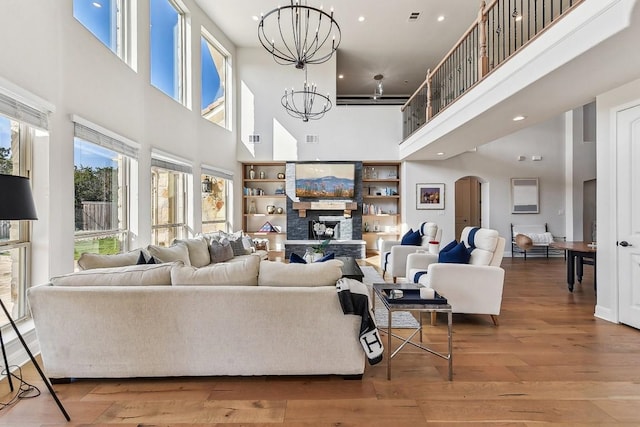 living room featuring a healthy amount of sunlight, an inviting chandelier, and hardwood / wood-style floors