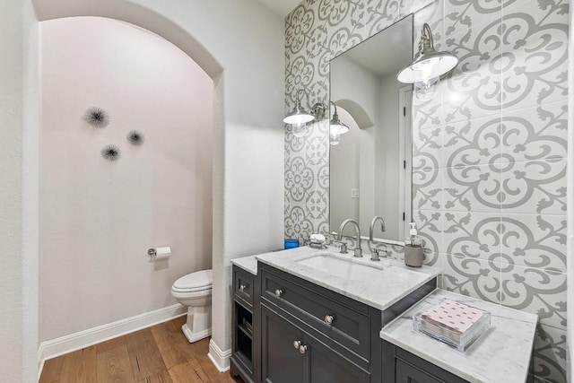 bathroom with hardwood / wood-style flooring, vanity, and toilet