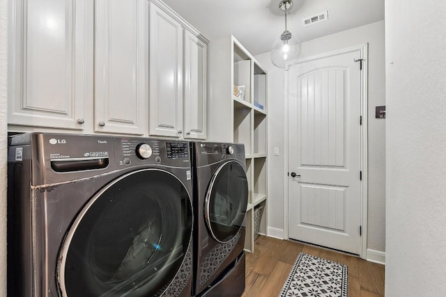 washroom featuring cabinets, dark hardwood / wood-style flooring, and separate washer and dryer