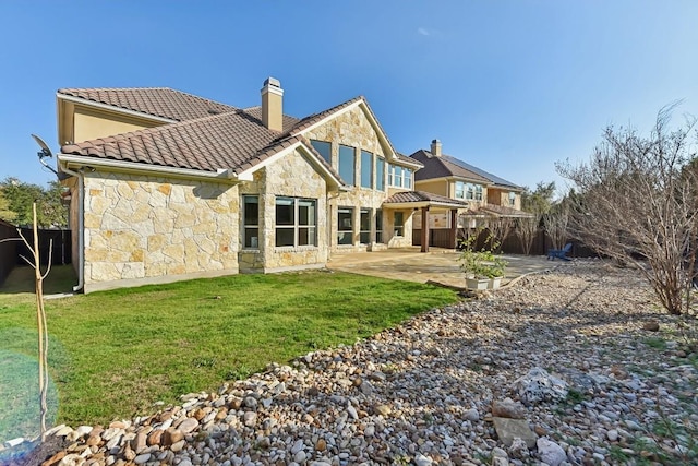 back of house featuring a patio area and a lawn